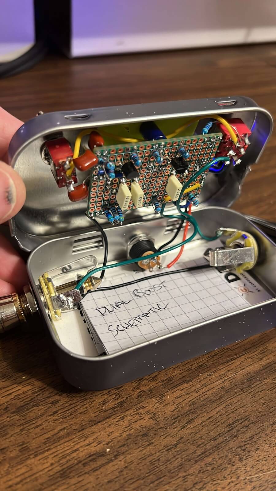 Completed perfboard dual-stage boost circuit and internal wiring inside the open tin enclosure