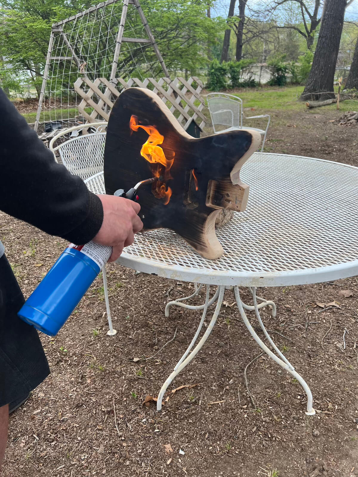 First Act guitar body being burned with a propane torch