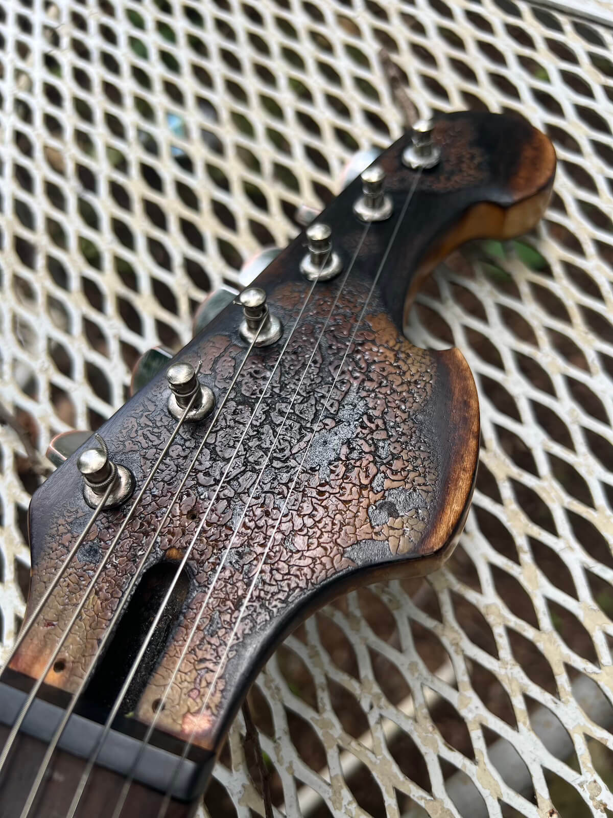 Close view of crackled burned finish on First Act headstock