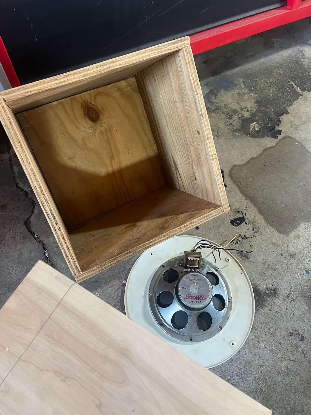 Salvaged speaker being fitted into the unfinished cabinet
